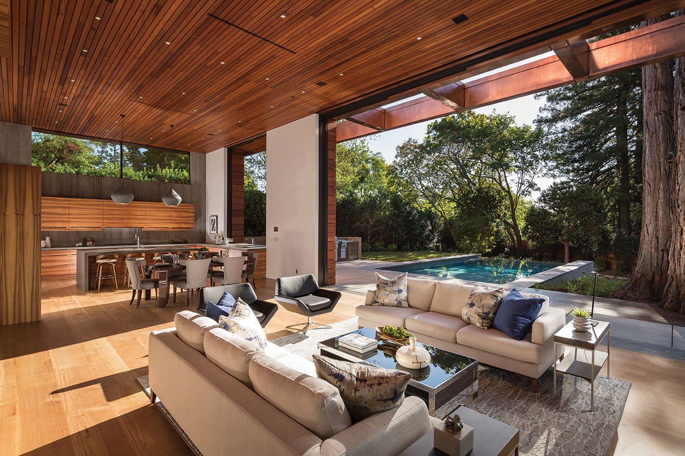 An indoor/outdoor space with a 14-foot tall LiftSlide Door that seamlessly connects a living room with outdoor pool area.