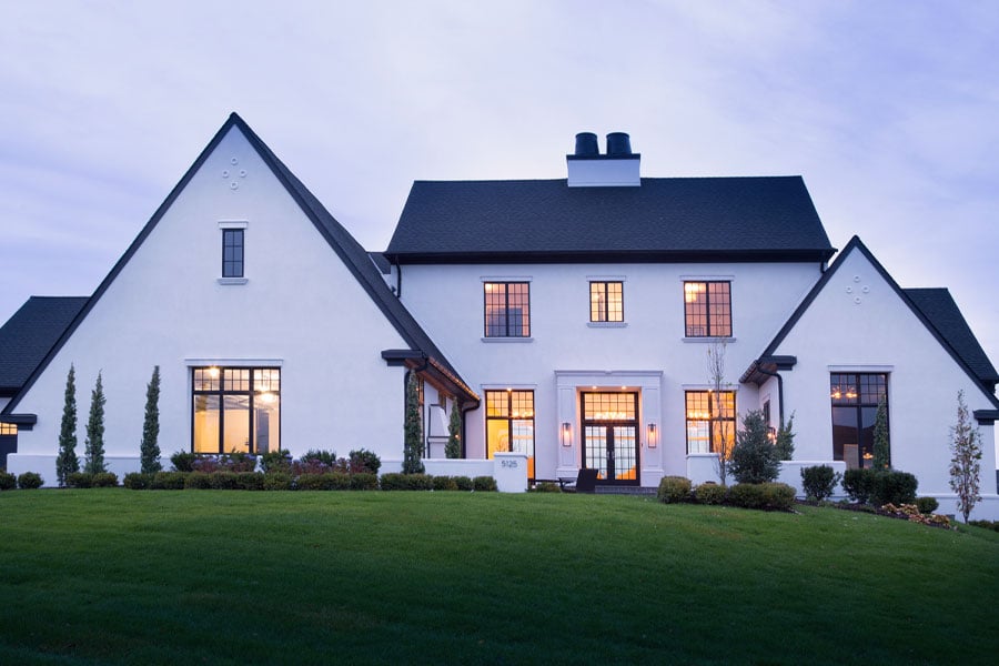 modern Tudor home on hill at dusk