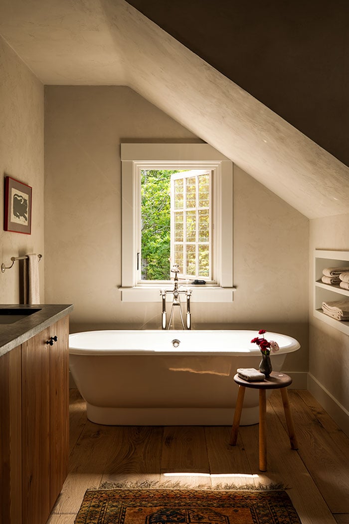 On the left, an image of a bedroom with a canopy bed and an A-Series Casement Window painted blue to match the shutters and trim around it. On the right, an image of a moody bathroom with a tub under a white A-Series Casement Window with colonial grilles.