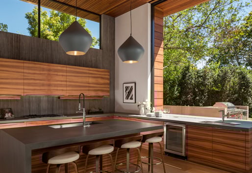 A monumental Andersen® Liftslide Pass-Through Window connects a kitchen with a patio.